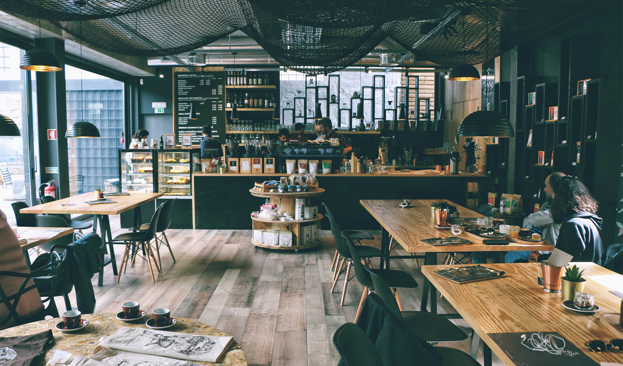 A modern café full of people working and building ideas, reflecting the reality that AI alone won’t save a business.